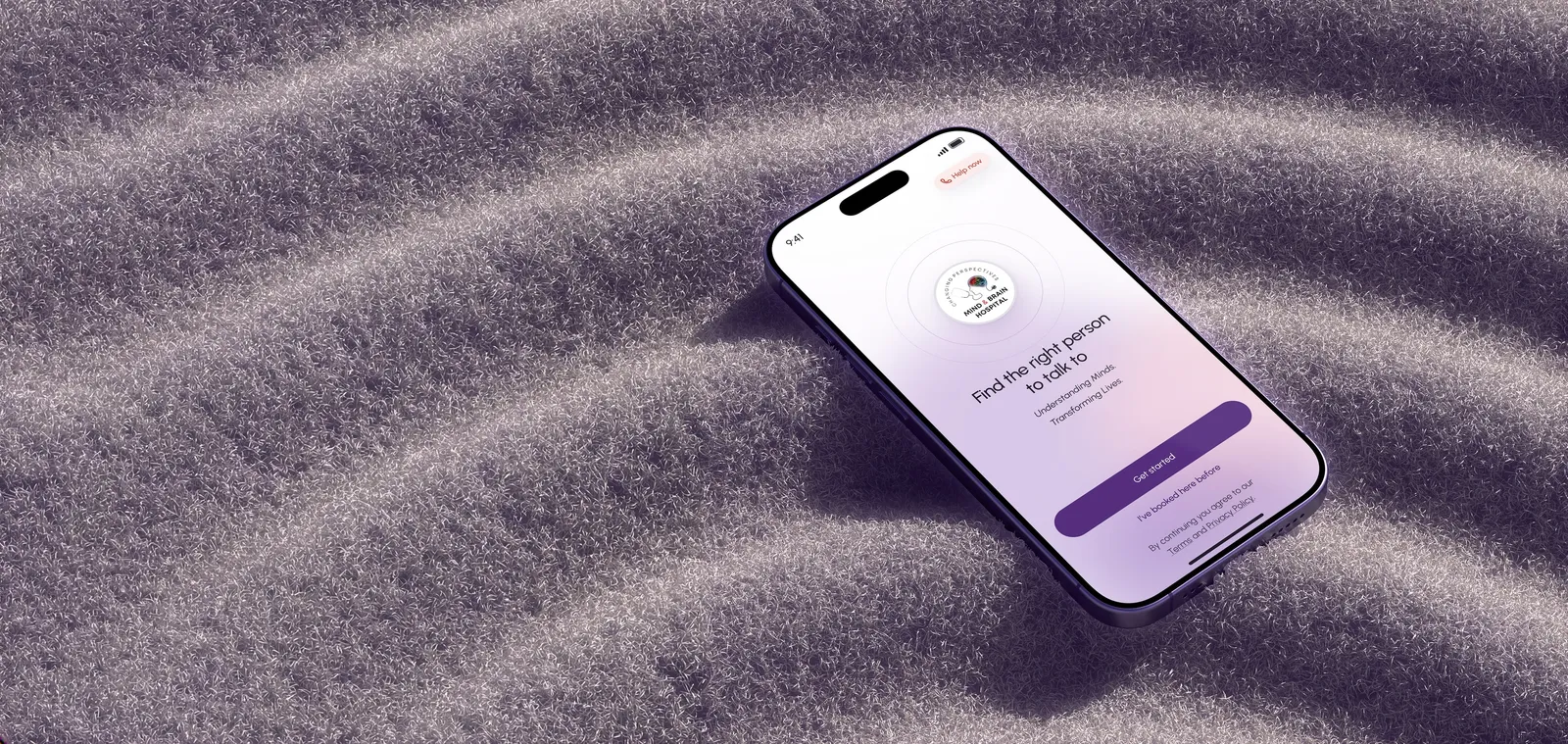 A phone showing the Mind & Brain app's welcome screen, resting on soft lilac ridges.