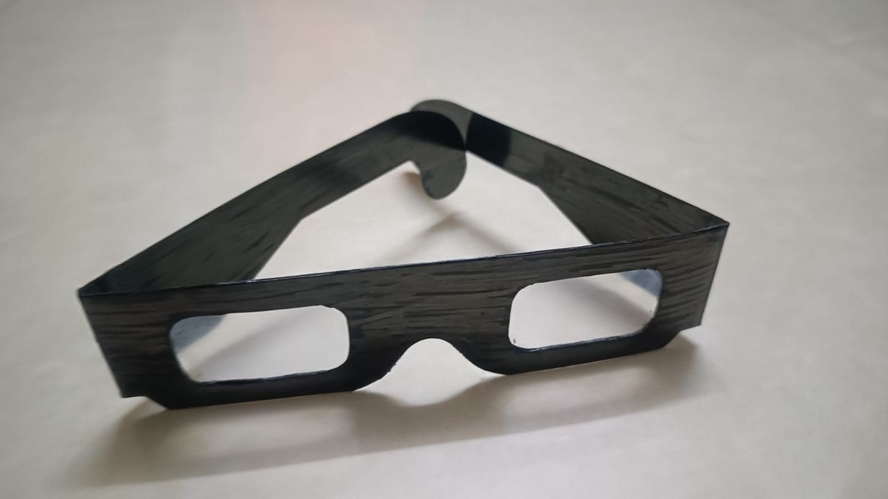The blurred glasses prop: a pair of dark wood-effect frames on a light surface.